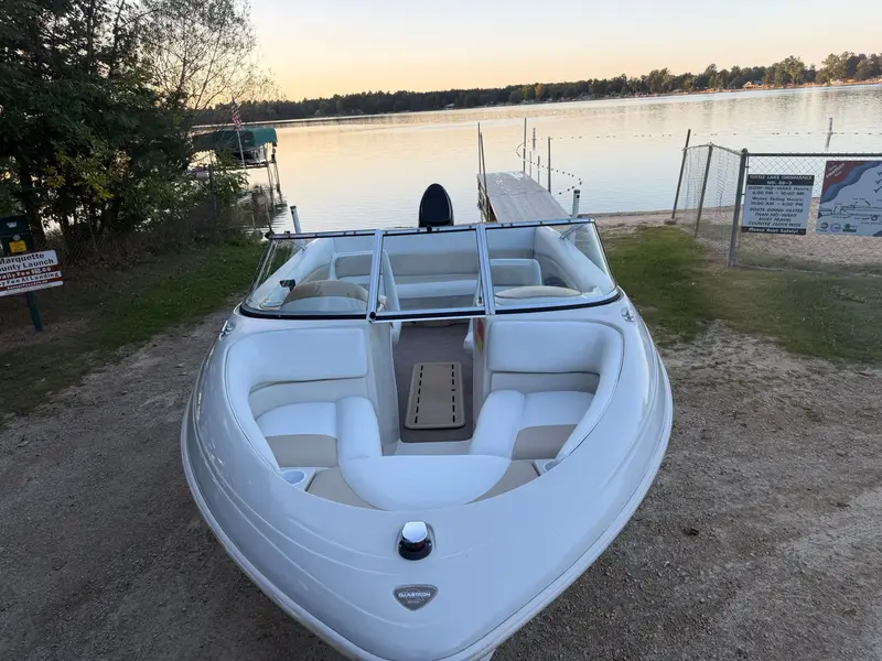 Glastron runabout on a trailer at the lake, bow seats in white and tan