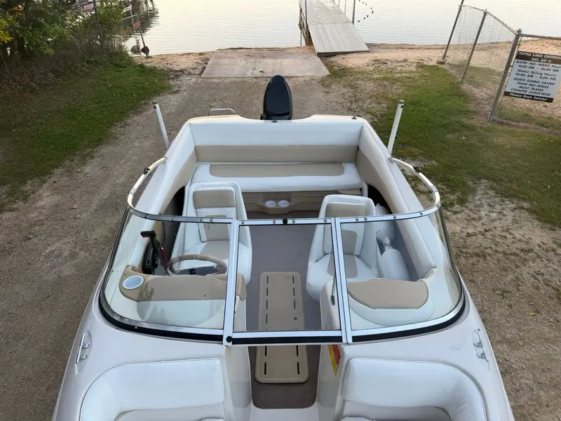 Glastron cockpit from above: white and tan bucket seats and rear bench