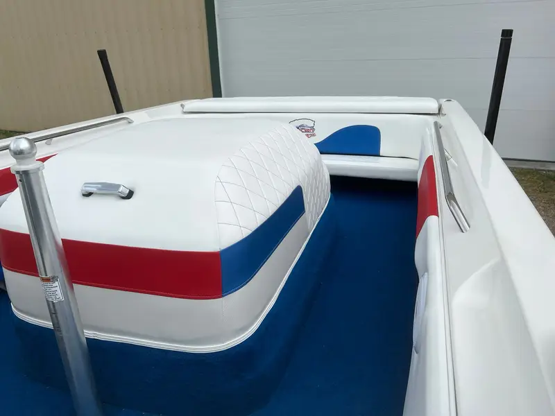 Engine cover wrapped in white with a red and blue stripe, rear bench behind it